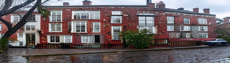Panoramic view of a terrace of red-brick Dublin Georgian houses with sash windows and brightly painted front doors, cast-iron railings, wet cobblestone street reflecting grey morning light, a single parked estate car, bare tree in the foreground, soft Irish spring drizzle
