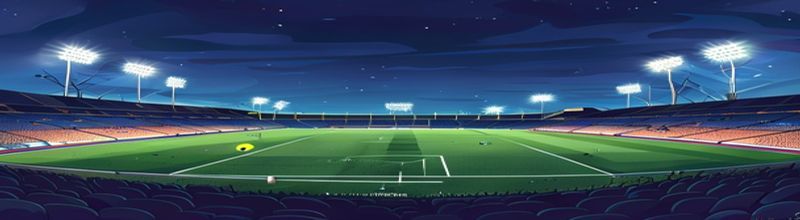 Panoramic view of an empty European football stadium at night, the pitch brightly lit by tall floodlights, the dark blue sky just above the rim of the upper tier, two banks of empty grandstand seating either side of the centre line, no people no faces no hands