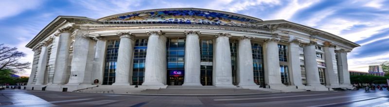 Panoramic wide-angle photograph of the Marriner S. Eccles Federal Reserve Board building facade in Washington, white marble columns and bronze eagle relief above the entrance, American flag visible to one side, overcast morning light, documentary realism, no people no faces no hands