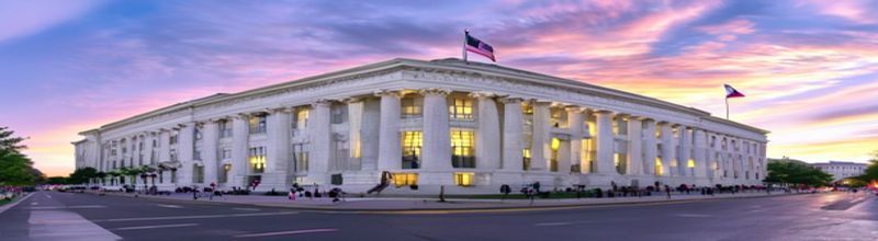 Panoramic view of the U.S. Federal Reserve Eccles Building in Washington DC at dawn, neoclassical white marble facade with American flags, empty street, soft golden light, no people no faces no hands